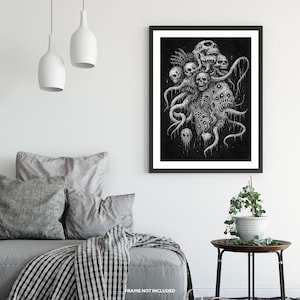 May include: A monochrome art print depicting a monstrous entity with multiple skulls and tentacles. The artwork is framed in black and mounted on a white wall. The print is a dark, gothic illustration, suitable for a horror theme.