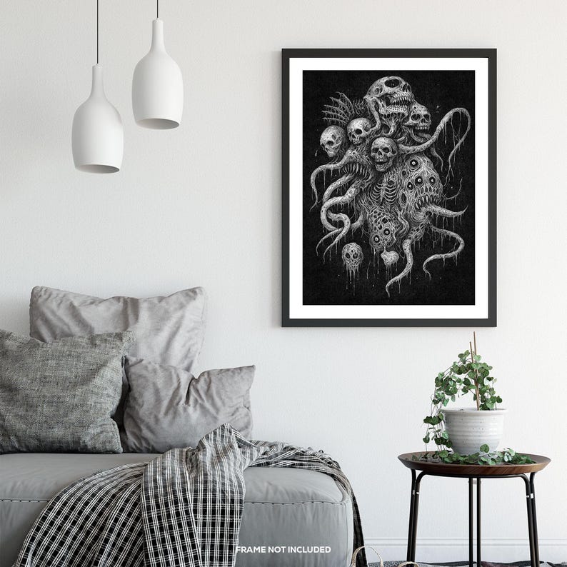 May include: A monochrome art print depicting a monstrous entity with multiple skulls and tentacles. The artwork is framed in black and mounted on a white wall. The print is a dark, gothic illustration, suitable for a horror theme.