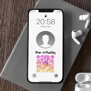 Puede incluir: Un teléfono inteligente blanco con una pantalla negra que muestra un código QR con el texto "Your #Hashtag" y la hora 20:58. El teléfono está sobre un cuaderno gris en una superficie de madera. Hay auriculares inalámbricos blancos en la superficie.