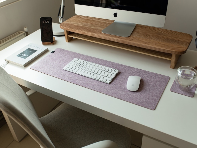 May include: A white desk with a light purple mouse pad, a white keyboard, a white mouse, a glass of water, and a book titled "So Good For You".