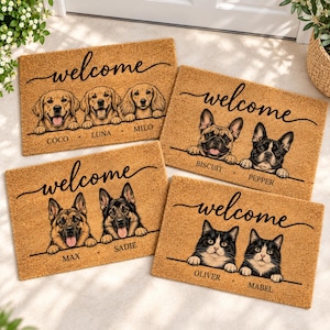 Puede incluir: Cuatro felpudos rectangulares de fibra de coco color canela con la palabra welcome en letra cursiva negra. Cada alfombra muestra ilustraciones personalizadas de mascotas con sus nombres impresos debajo: Coco, Luna, Milo, Biscuit, Pepper, Max, Sadie, Oliver y Mabel.