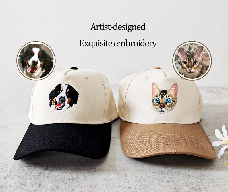 May include: Two baseball caps with embroidered pet portraits. One cap has a black peak and a dog portrait, the other has a tan peak and a cat portrait. The text "Artist-designed Exquisite embroidery" is above the caps.