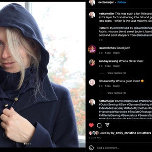 May include: A woman wearing a navy blue hooded jacket with a high neck collar. The jacket has a zipper and two buttons. The woman is looking at the camera. The caption reads: "This was such a fun little project! It's a perfect extra layer for transitioning into autumn and great for all my hood-less coats - which is the vast majority. So cosy! Pattern: #ComfortHood by @isainstitches Fabric: viscose blend sweat (outer), bamboo spandex (lining), cord and cord stoppers from @aboekenstoffen"