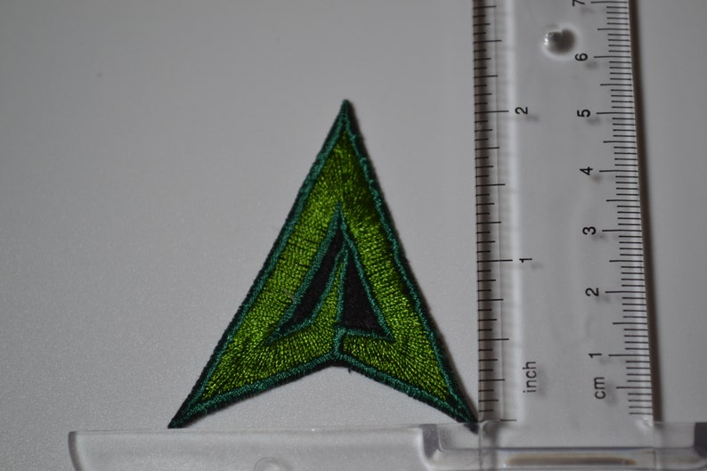 Op de afbeelding: Groen en zwart geborduurd pijl-patch, ongeveer 5 cm hoog.