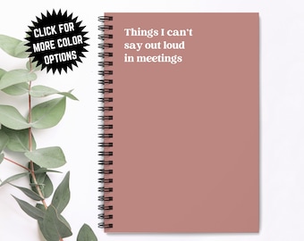 May include: A blush pink spiral bound notebook with the text "Things I can't say out loud in meetings" printed in white.