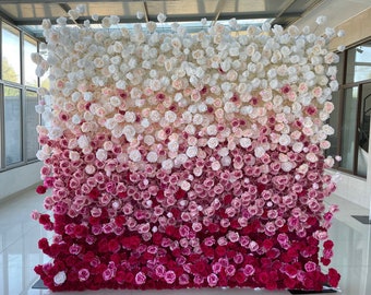 May include: A wall covered in artificial flowers, with a gradient of white, pink, and red roses.