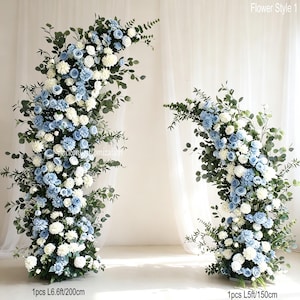May include: Two floral arrangements labelled Flower Style 1, featuring light blue and white roses, dahlias, and green eucalyptus foliage. The taller piece measures 200 cm, while the shorter piece measures 150 cm in total length.