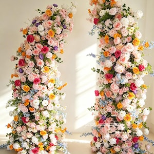 Peut inclure: Deux grands arrangements floraux composés de fleurs roses, orange, jaunes, blanches et bleues avec du feuillage vert. L'arrangement de gauche est marqué 1pcs L6ft/180cm et celui de droite 1pcs L6.6ft/200cm. Le texte indique Flower Style 1.