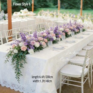 May include: A white lace tablecloth is decorated with a floral arrangement of purple, pink, and white flowers. The table is set with plates, glasses, and chairs. The text "Flower Style 6" is visible. Table length is 200cm, width is 40cm.