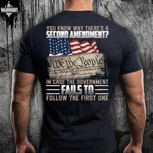 May include: A black short-sleeved t-shirt featuring a graphic on the back. The text reads: YOU KNOW WHY THERE'S A SECOND AMENDMENT? IN CASE THE GOVERNMENT FAILS TO FOLLOW THE FIRST ONE. It includes an American flag and a We The People document image.