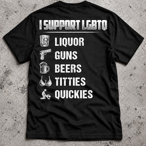 Puede incluir: Una camiseta negra de manga corta con texto blanco desgastado que dice I SUPPORT LGBTQ seguido de una lista: LIQUOR con un vaso, GUNS con una pistola, BEERS con una jarra, TITTIES con un sujetador y QUICKIES con un icono gráfico.
