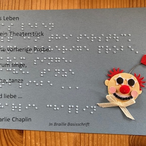 Braille-/Blindenschrift (Basis) Spruchkarte: "... Darum singe, lache, tanze und liebe ..." von Charlie Chaplin, taktile Karte, mit 3D Clown
