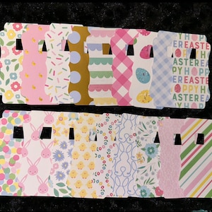 May include: A set of 18 Easter-themed gift tags with various patterns and designs. The tags are pink, blue, yellow, and green with bunny rabbits, chicks, eggs, and polka dots. The tags have a scalloped edge and a hole for string or ribbon.