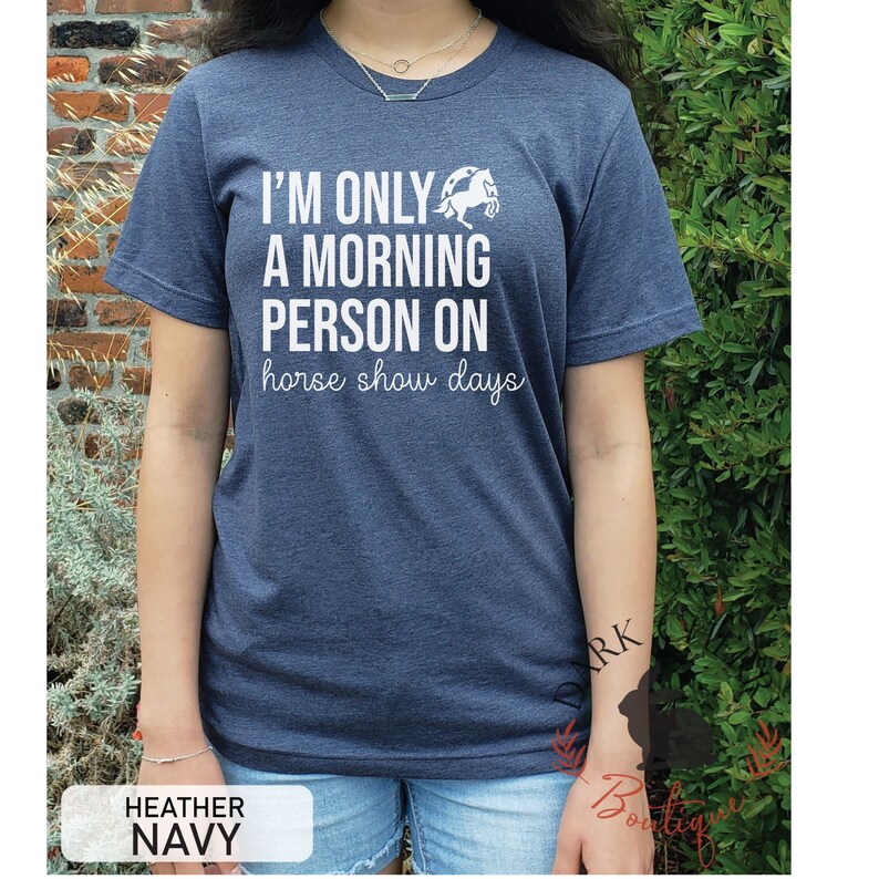 K&ouml;nnte beinhalten: Ein marineblaues T-Shirt mit wei&szlig;em Text, der "Ich bin nur ein Morgenmensch an Pferdeshow-Tagen" lautet. &Uuml;ber dem Text befindet sich eine wei&szlig;e Silhouette eines Pferdes.
