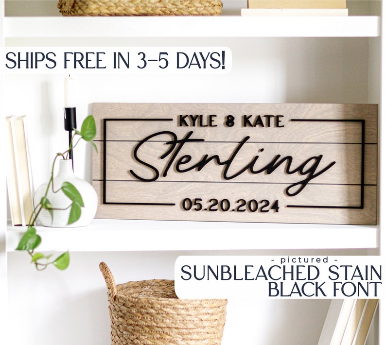 May include: A wooden sign with the text "KYLE & KATE Sterling 05.20.2024" in black lettering. The sign is on a white shelf with a potted plant and a basket.
