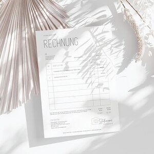 May include: A white invoice form with the heading "RECHNUNG" in black text. The form includes sections for "AN", "DIENSTLEISTUNG", "PREIS", and "SUMME". The bottom of the form includes contact information and a logo with the text "Studio Name Fotografie".