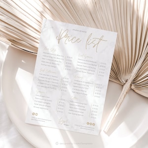 Op de afbeelding: Een prijslijst voor een schoonheidssalon met diensten zoals haar knippen, nagelbehandelingen, waxen en hairextensions. De lijst is gedrukt op wit papier met een marmer effect en gouden letters.
