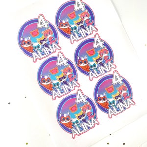 May include: Five round stickers with a purple, pink and blue gradient background. Each sticker features a group of cartoon cats wearing superhero costumes. The text "ALINA 4" is printed on each sticker.