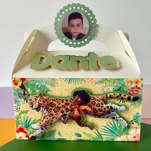 May include: A white favor box with a green and gold glitter name tag that says "Dante". The box has a jungle theme with a cartoon image of a boy running with a jaguar. A green circle with a white border and a photo of a young boy is on the top of the box.
