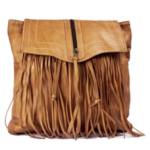 May include: A brown leather bag with a fringe detail. The bag has a zipper closure and a flap with stitching.