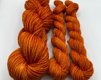Peut inclure: Trois écheveaux de fil orange, un plus grand et deux plus petits.