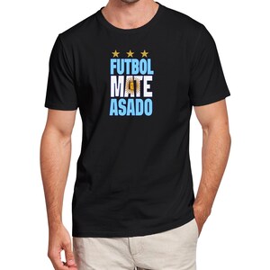 May include: Black t-shirt with a blue and white graphic that says "FUTBOL MATE ASADO" with three gold stars above the text.