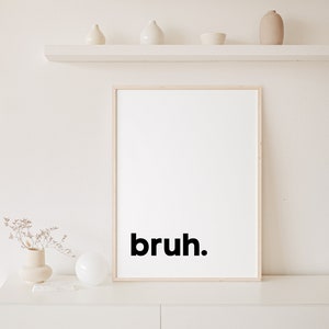 May include: A framed print with the word "bruh" in black text on a white background.