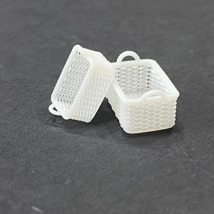 May include: Two white wicker baskets, one is open and the other is closed. The baskets are made of a woven material and have a handle.