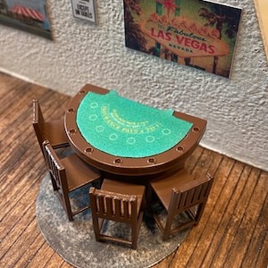 May include: A miniature green felt-covered table with brown wooden chairs. The table has a roulette wheel design and the text "Insurance Pays 2 to 1".