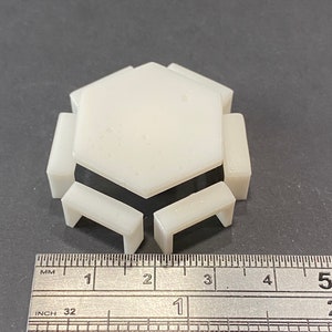 Könnte beinhalten: Weißer, sechseckiger Miniaturtisch mit vier passenden Stühlen. Tisch und Stühle sind etwa 2,5 cm hoch.