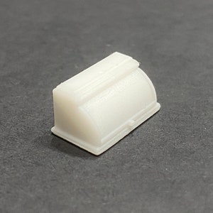 May include: A white plastic bread box with a rounded top and a hinged lid. The box has a simple design with no embellishments.