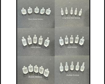 May include: Assortment of clear plastic miniature bottles in various shapes and sizes, including short bullet, long neck beer, liquor, jack, buffalo, and bullet bottles.