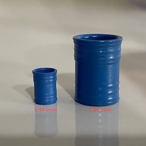 May include: Two blue plastic barrels, one larger than the other. The larger barrel is labeled "1/24 scale" and the smaller barrel is labeled "1/48 scale".