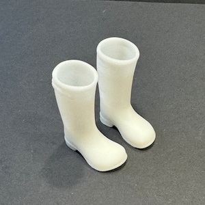 May include: A pair of white rubber boots. The boots are tall and have a rounded toe.