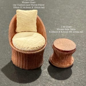 May include: Miniature 1:48 scale wicker chair with cushion and throw pillow, measuring 13mm x 14.5mm x 15mm tall, and a matching side table, 8.25mm x 8.3mm x 6.10mm tall. Both pieces are made of woven material and are light brown in color.