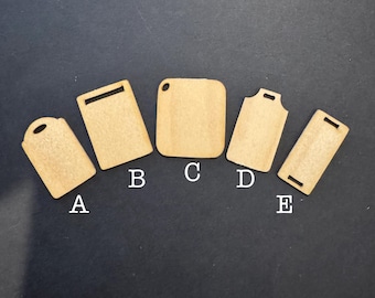 May include: Five small, light brown wooden cutting boards in various shapes. Each board is labeled with a letter from A to E. The boards have different handle designs, including a hole, a rectangular cutout, and a curved top.