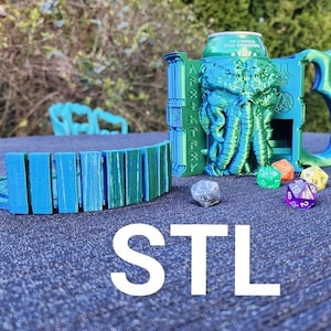 Puede incluir: Una torre de dados de Cthulhu impresa en 3D en verde y azul con un portavasos y una bandeja de dados separada. La torre tiene un diseño de Cthulhu en la parte delantera y el texto "Cthulhu Fhtagn" en el lateral. La bandeja de dados tiene un diseño curvo y segmentado. Hay seis dados en la mesa, incluyendo un d20 blanco y negro, un d6 rojo, un d6 amarillo, un d6 verde, un d6 azul y un d6 morado.
