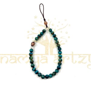 May include: A teal blue and gold tiger's eye beaded phone charm with a brown leather strap and a small pink stone accent.