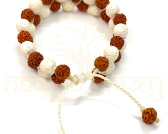 May include: A white and brown beaded bracelet with a knotted closure. The bracelet is made of small, round beads.