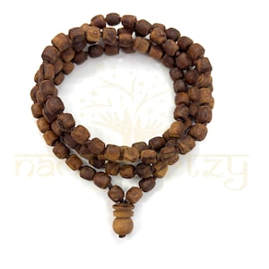 May include: A brown wooden mala bead necklace with a tassel. The beads are square shaped and the necklace is approximately 108 beads long.