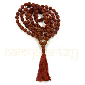 Puede incluir: Un collar de cuentas mala marrón con 108 cuentas y un borla. Las cuentas están hechas de semillas de rudraksha.