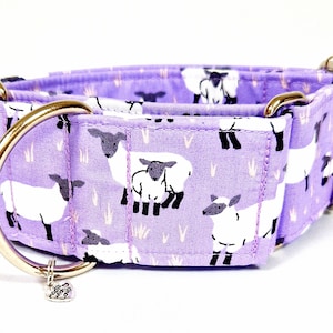 May include: A purple dog collar with a white sheep pattern and gold hardware. The collar has a small silver charm attached to it.