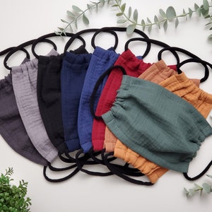 May include: A set of 10 face masks in various colours, including grey, black, blue, red, orange, and green. The masks are made of a soft, breathable fabric and have elastic ear loops.