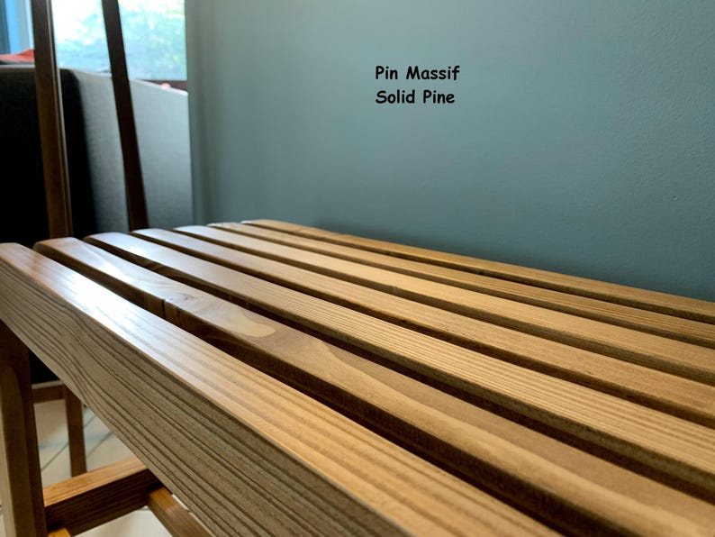 Gros plan en angle sur l'assise à lattes en pin massif du banc, avec le texte Pin Massif Solid Pine affiché en haut à droite.