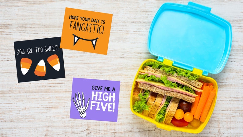 May include: Three Halloween-themed lunchbox notes with fun sayings. The notes say "You are too sweet!" with candy corn, "Hope your day is Fangastic!" with fangs, and "Give me a High Five!" with a skeleton hand.
