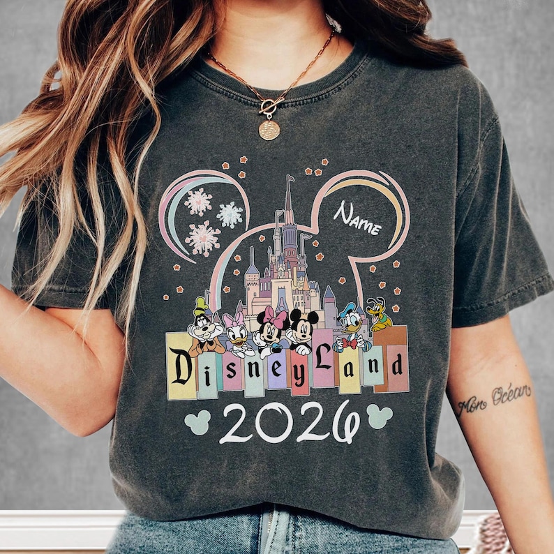A person wearing a t-shirt with a Disney theme and the text "Disneyland 2026" printed on it.