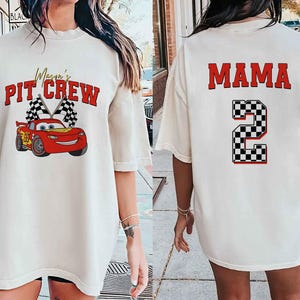 a woman wearing a white shirt with a red car on it