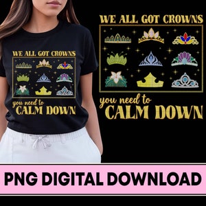 May include: Black t-shirt with a gold graphic design featuring the text "We all got crowns, you need to calm down". The graphic includes a variety of crowns with jewels and stars.