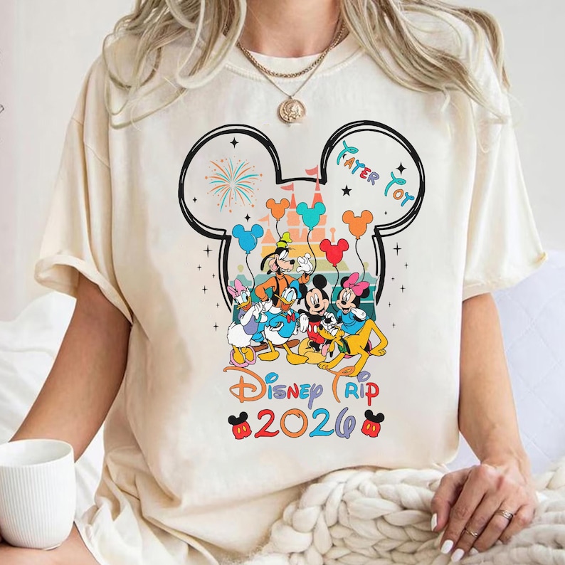 A person wearing a white t-shirt with a Disney-themed graphic design featuring Mickey Mouse, Donald Duck, Goofy, and Minnie Mouse.