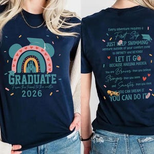 a woman wearing a blue t-shirt with a colorful graphic and text on it.